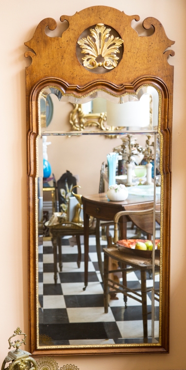 $1,250. George I style walnut mirror with shaped beveled glass in carved frame with gilt accents.
